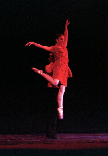 Male dancer holds up a female dancer. 